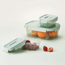 Set of pastel green storage boxes holding oranges and strawberries, displayed on a neutral background.