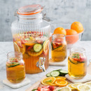 Kilner glass drinks dispenser filled with fruit punch and slices of cucumber, strawberries, and oranges, with matching mason jar glasses.