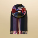 Soft woven scarf in bold check pattern with shades of navy, pink, red, and olive, finished with tassel fringe.