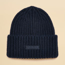 Flat lay of a navy knitted beanie hat with folded brim and Joules branding.