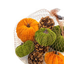 A close-up of the mesh bag showing the textured velvet pumpkins in orange and green with brown stalks, mixed with pine cones.