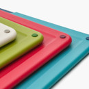 Stack of Joseph Joseph Folio Icon chopping boards showing textured surfaces and corner grips in assorted colours.