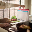 Person using Joseph Joseph Folio Icon chopping board set in a modern kitchen with fresh ingredients on the worktop.
