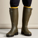 Le Chameau green wellington boots being worn from the front, showing their tall fit and chunky black soles.