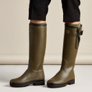 Le Chameau women’s olive green tall wellington boots being worn, showing the knee-high fit and adjustable calf design.