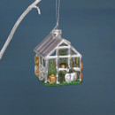 Close-up of a silver greenhouse Christmas tree decoration featuring miniature plants, pots and gardening accessories with a green glitter base.