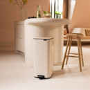 A view of a cream predal bin in a kitchen