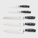Five stainless steel kitchen knives with black riveted handles laid out in size order, including chef’s, bread, carving, utility, and paring knives.
