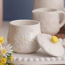 Price & Kensington Daisy sugar bowl with embossed floral pattern, shown open beside matching milk jug and fresh flowers.