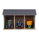 A model farm shed with three compartments, housing a green tractor, a blue tractor, and an orange trailer. Each vehicle is neatly parked inside.