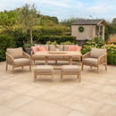 Cora rope outdoor lounge dining set with wooden table, three-seat sofa, armchairs and footstools in a landscaped garden setting, featuring beige cushions and natural wood frames.