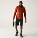 A front view of a man wearing an orange Regatta half zip fleece on a white background