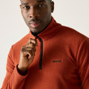 A close up view of a man wearing an orange Regatta half zip fleece on a white background