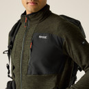 A close up view of a man wearing a dark green full zip Regatta fleece on a white background