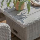 Close-up of the grey slatted wood effect tabletop with wicker edging, featuring a potted plant casting a soft shadow.