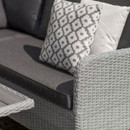 Close-up of the corner sofa’s smoke grey seat cushion, while highlighting the wicker armrest detail.