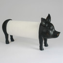 A whimsical paper towel holder designed like a pig, with a black head and legs and the paper towel roll forming its body, set against a plain background.