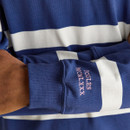 A close up view of the sleeve on a blue and white striped Joules rugby shirt