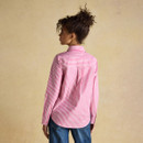 Rear view of a woman in a pink and white striped long-sleeve shirt, showing the relaxed fit and back yoke detail.