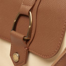 Close-up of a tan faux-leather flap with a metal ring and embossed Joules branding on a cream tote bag.