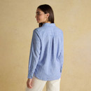 Back view of a woman in a light blue check shirt with long sleeves, showing the relaxed fit and curved hem.