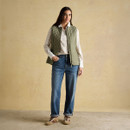 Full outfit featuring an olive green quilted gilet layered over a printed blouse, styled with relaxed blue jeans and lace-up boots for a casual countryside look.