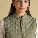 Close-up of the upper front of an olive green quilted gilet showcasing the diamond stitching and stand collar.