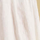 A close-up of the lightweight white fabric of a sleeveless blouse, showing its soft texture and subtle weave.