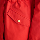 Close-up of a flap pocket with a gold popper on a bright red women’s raincoat.