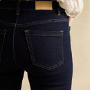 Back waistband and pocket detail of dark-wash skinny jeans, showing the Joules branded leather patch.