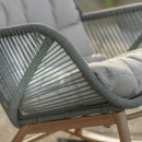Detail of the fern green rope weave and light coloured seat cushion in sunlight.