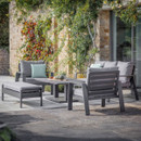 Anthracite garden lounge set on stone patio with two armchairs, a bench and a square adjustable table.