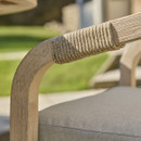 Close-up of rope-wrapped armrest on a natural wooden outdoor dining chair.