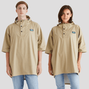 Two models wear a beige waterproof poncho with a hood, black button placket, wide sleeves, and a small chest logo patch.
