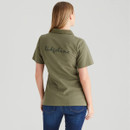 Back view of the olive green polo shirt showing a large Ridgeline logo printed across the upper back. The model wears blue jeans, photographed against a neutral grey studio background.