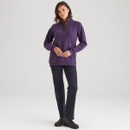 Full-body shot of the woman wearing the purple quarter-zip sweatshirt paired with dark trousers and boots against a plain background.
