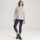 Full-length view of the model styled in the patterned high-neck top with dark leggings, green socks and black ankle boots, creating a smart-casual look.