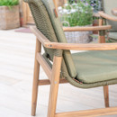 Close-up of Meadow dining chair showing woven rope backrest, wooden armrests and green seat cushion.
