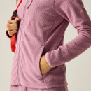 Close-up of the pink jacket fabric and front pockets, with the model’s hand in the pocket.