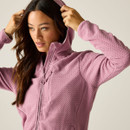 Close-up of the model pulling up the hood on the pink textured zip-up jacket.