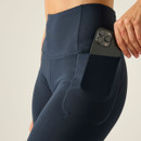 Close-up of navy high-waisted leggings showing a side pocket with a smartphone inside.