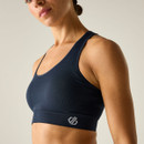 Close-up of navy racerback sports bra with wide underband and logo detail.