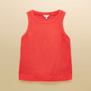 Flat lay of a sleeveless red linen top on a beige backdrop, showing the simple neckline and clean, minimal design.