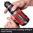Close-up of hands adjusting a red and black power drill, showing the Einhell brand. Text reads, "Selectable functions: screwing, drilling or impact drilling."