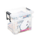 Clear lidded storage box with black clip handles, packed with art supplies including paints, brushes and a mixing palette.