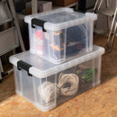 Pair of clear storage boxes with secure clip-lock lids, filled with tools and cables in a workshop.
