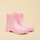 Pair of light pink ankle-height rubber rain boots on a beige background, shown at a three-quarter angle.