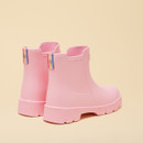 Rear angle view of a pair of light pink rain boots showing the colourful striped pull tabs and ribbed heel detailing.