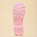 Bottom view of a light-pink rain boot showing the chunky, textured tread pattern on the sole.