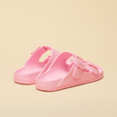 Rear angle view of light pink double-strap sandals showing the contoured footbed and textured heel.